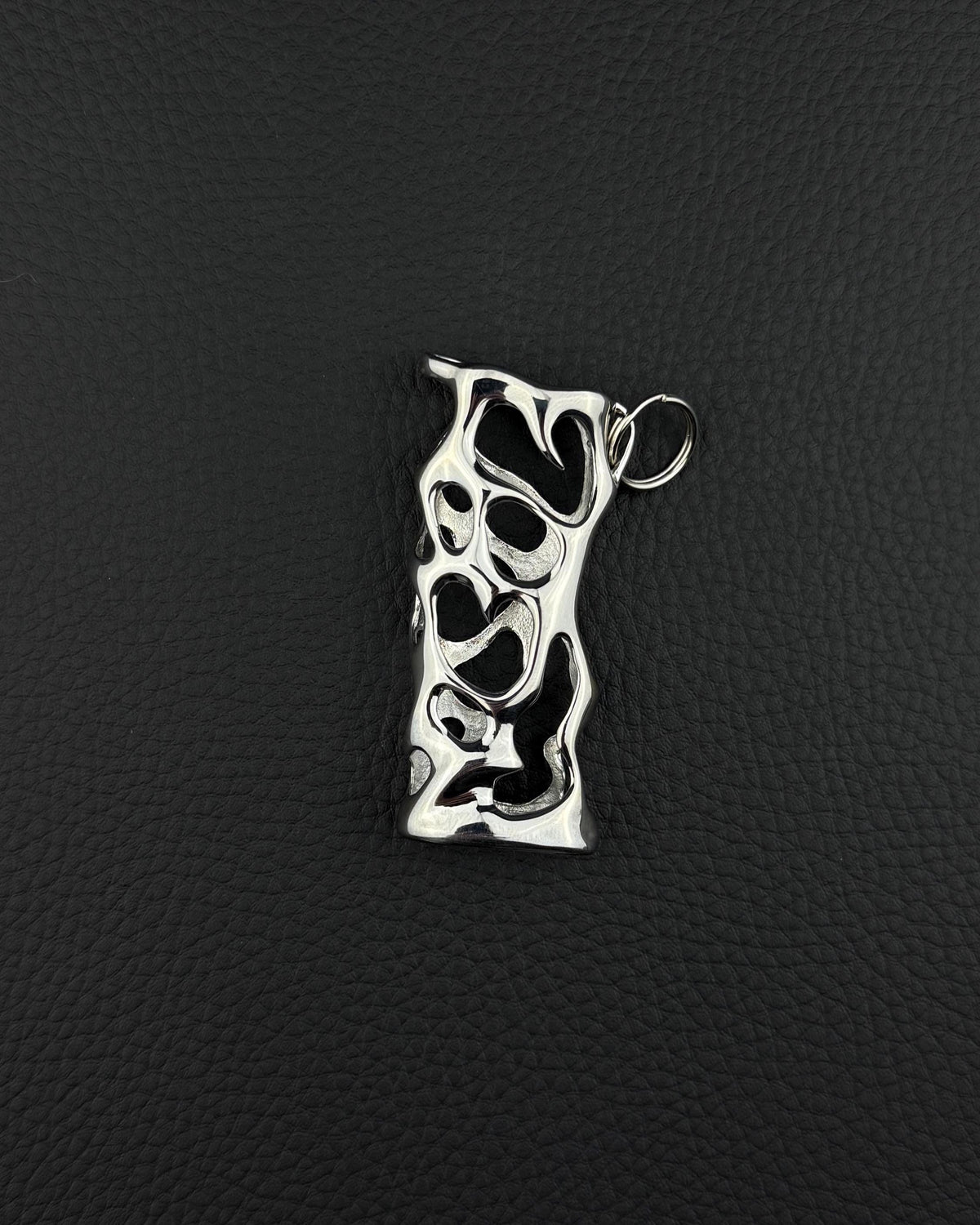 A silver stainless steel lighter sleeve featuring organic cutout pattern. cyber sigilism style