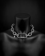 A handmade silver industrial chain necklace with thick, bold, large, chunky, rectangular links with a brass padlock and two keys. The necklace is made of stainless steel. The necklace is made from thick 6mm chain. The necklace includes a quick link carabiner and a smiley pendant.