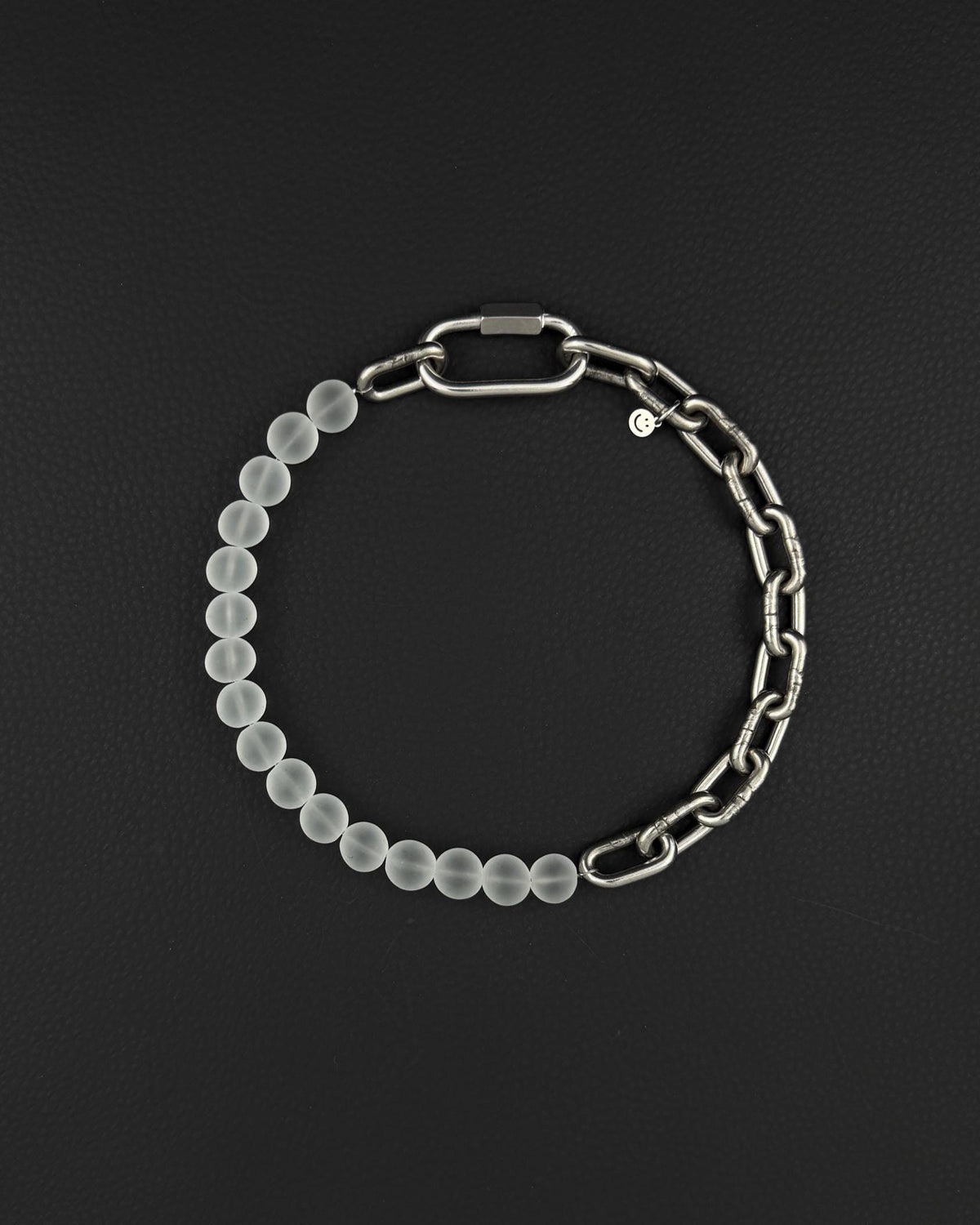 a stainless steel metal heavy industrial chunky chain necklace. half of the necklace is made out of chain and half of frosted transparent milky colourless glass beads, the necklace is closed with a rectangular clasp