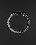 a stainless steel metal heavy industrial chunky chain necklace. half of the necklace is made out of chain and half of frosted transparent milky colourless glass beads, the necklace is closed with a rectangular clasp