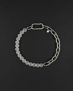 a stainless steel metal heavy industrial chunky chain necklace. half of the necklace is made out of chain and half of frosted transparent milky colourless glass beads, the necklace is closed with a rectangular clasp