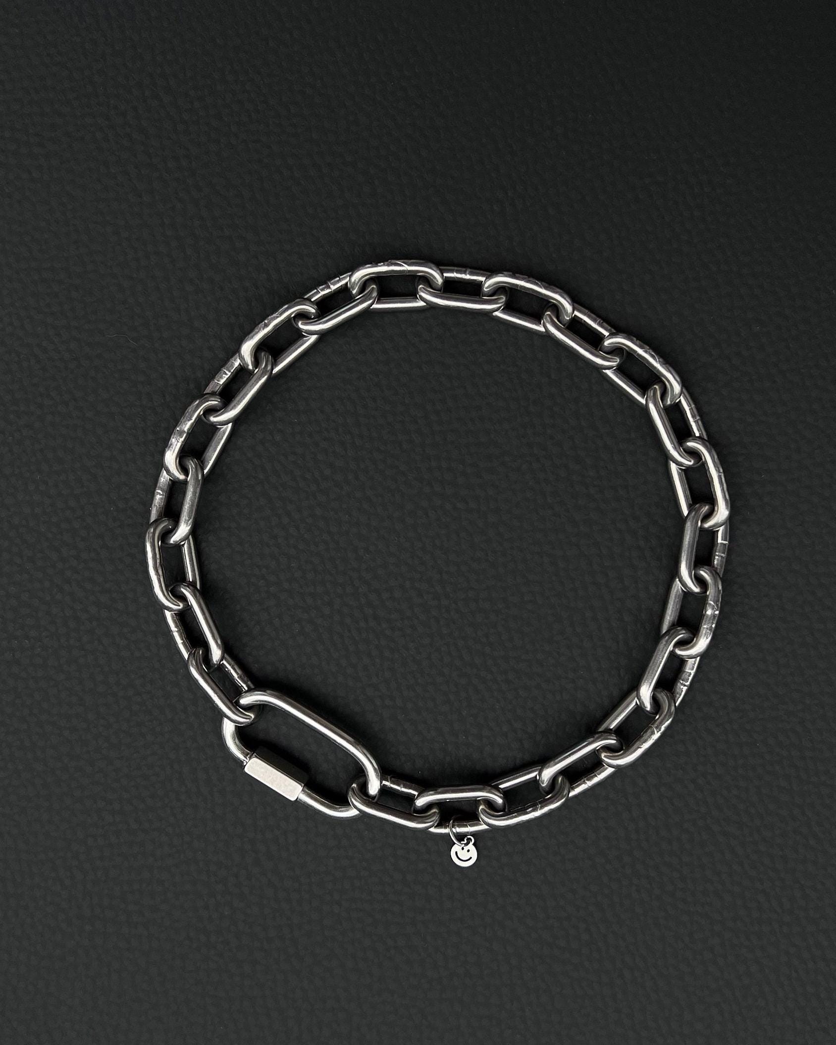 A handmade silver industrial chain necklace with large rectangular links. The necklace is made of stainless steel. The necklace is made from thick 4mm chain. The necklace includes a quick link carabiner and a smiley pendant.