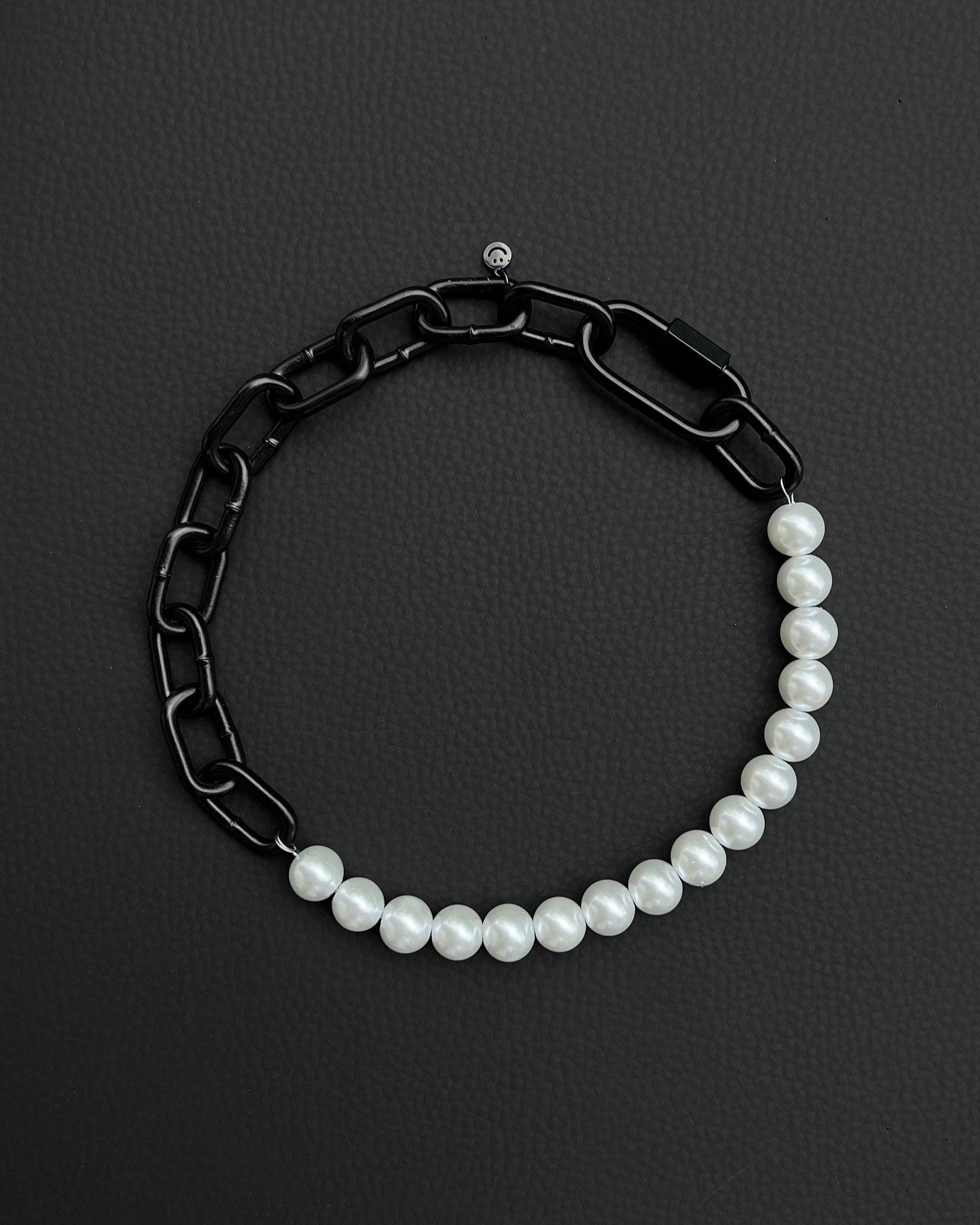 A handmade black industrial chain necklace with large, chunky, rectangular links. The necklace is made of stainless steel. The necklace is made half-half from thick 4mm chain and 12mm glass white pearl beads. The necklace includes a black quick link carabiner and a smiley pendant.