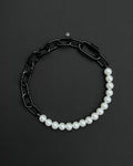 A handmade black industrial chain necklace with large, chunky, rectangular links. The necklace is made of metal steel. The necklace is made half-half from thick 4mm chain and 12mm glass white pearl beads. The necklace includes a black quick link carabiner and a smiley pendant.