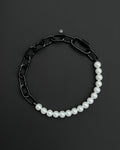 A handmade black industrial chain necklace with large, chunky, rectangular links. The necklace is made of stainless steel. The necklace is made half-half from thick 4mm chain and 12mm glass white pearl beads. The necklace includes a black quick link carabiner and a smiley pendant.