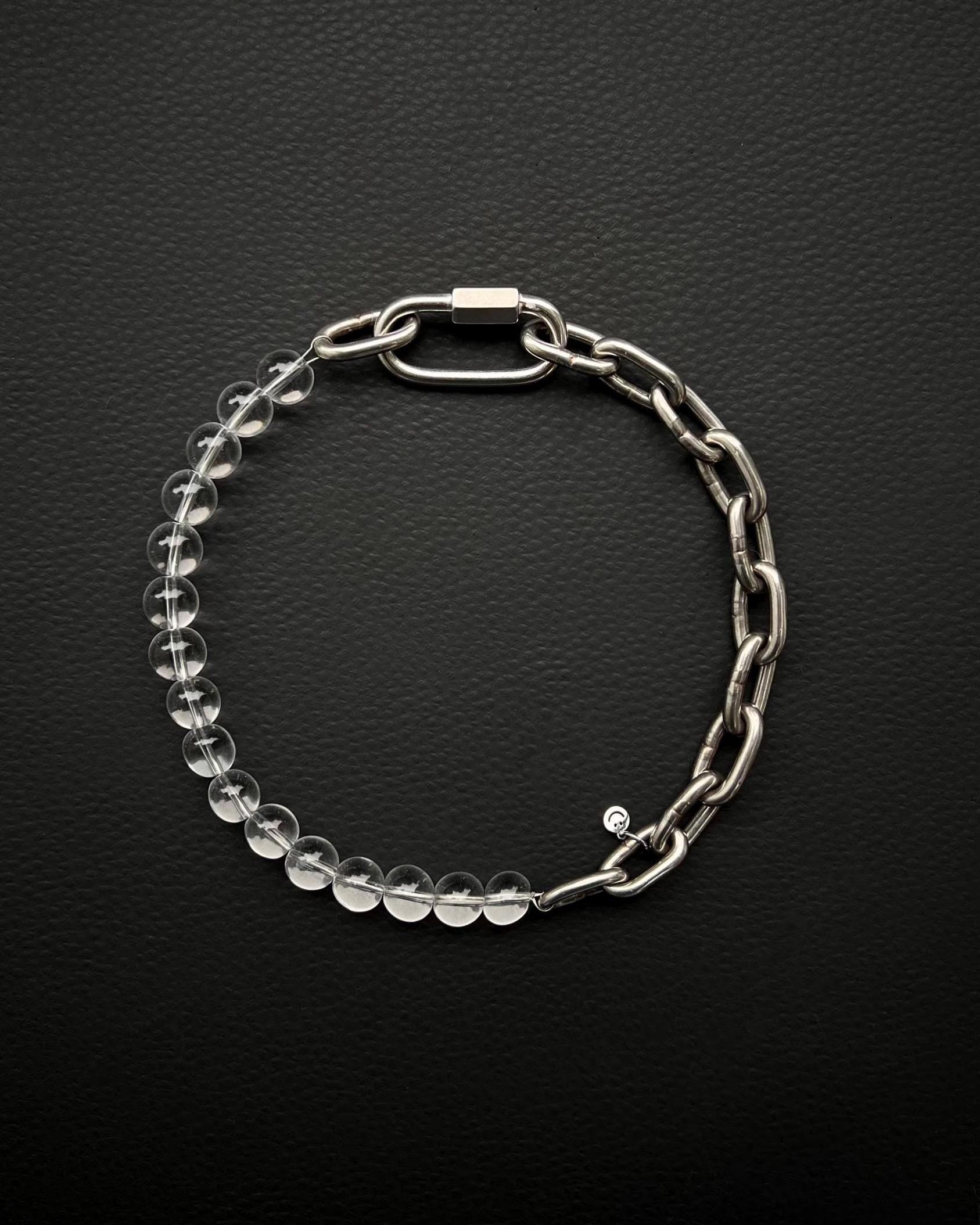 A handmade silver industrial chain necklace with large, rectangular links.
The necklace is made of stainless steel. The necklace is made half-half from thick 4mm chain and 12mm clear glass beads.The necklace includes a quick link carabiner and a smiley pendant.