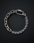 May include: A silver chain bracelet with a clear crystal bead accent. The chain has a clasp closure.
