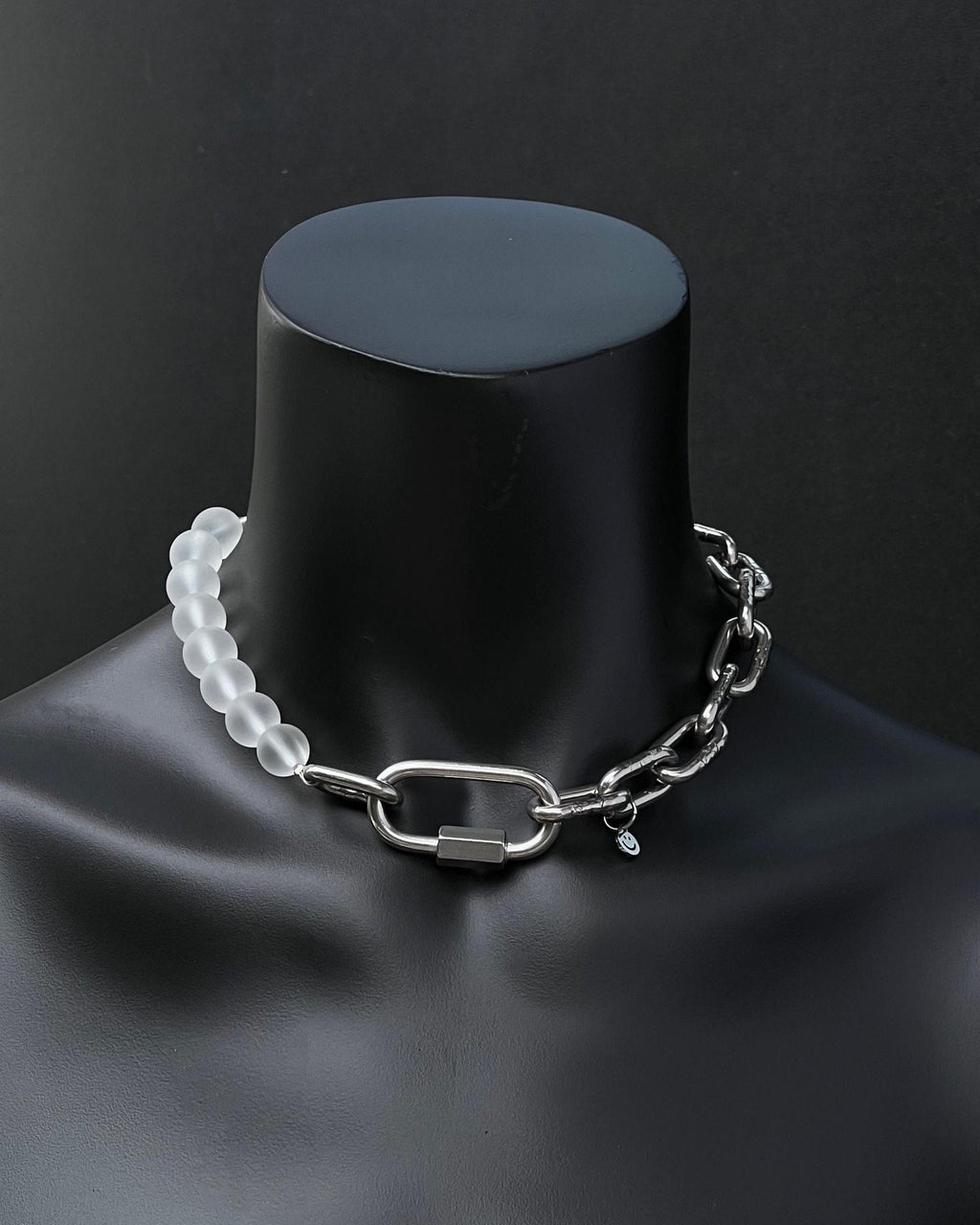 A handmade silver industrial chain necklace with large, rectangular links.
The necklace is made of stainless steel. The necklace is made half-half from thick 4mm chain and 12mm frosted mat glass clear beads. The necklace includes a quick link carabiner and a smiley pendant.