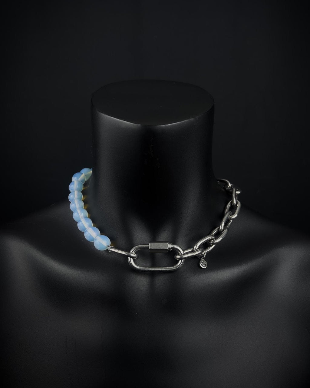 A handmade silver industrial chain necklace with large, chunky, rectangular links. The necklace is made of stainless steel. The necklace is made half-half from thick 4mm chain and 12mm opalite glass white light blue semi-transparent beads. The necklace includes a quick link carabiner and a smiley pendant.