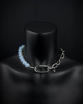 A handmade silver industrial chain necklace with large, chunky, rectangular links. The necklace is made of stainless steel. The necklace is made half-half from thick 4mm chain and 12mm opalite glass white light blue semi-transparent beads. The necklace includes a quick link carabiner and a smiley pendant.