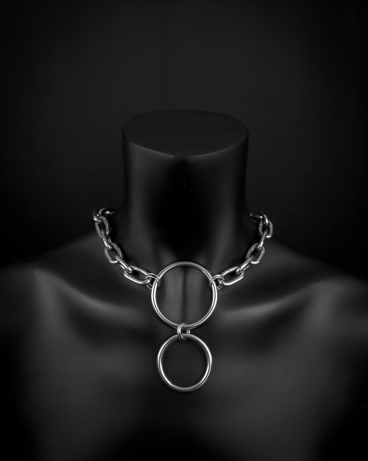 A handmade silver industrial chain ring necklace with large, rectangular links. The necklace is made of stainless steel. The necklace is made from thick 4mm chain and two rings. The necklace includes a quick link carabiner and a smiley pendant.