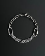 Handmade stainless steel martingale chain choker with two industrial chain types, two quick link clasps and a small smiley charm. Silver finish necklace photographed on a black background.