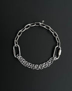 Handmade stainless steel martingale chain choker with two industrial chain types, two quick link clasps and a small smiley charm. Silver finish necklace photographed on a black background.