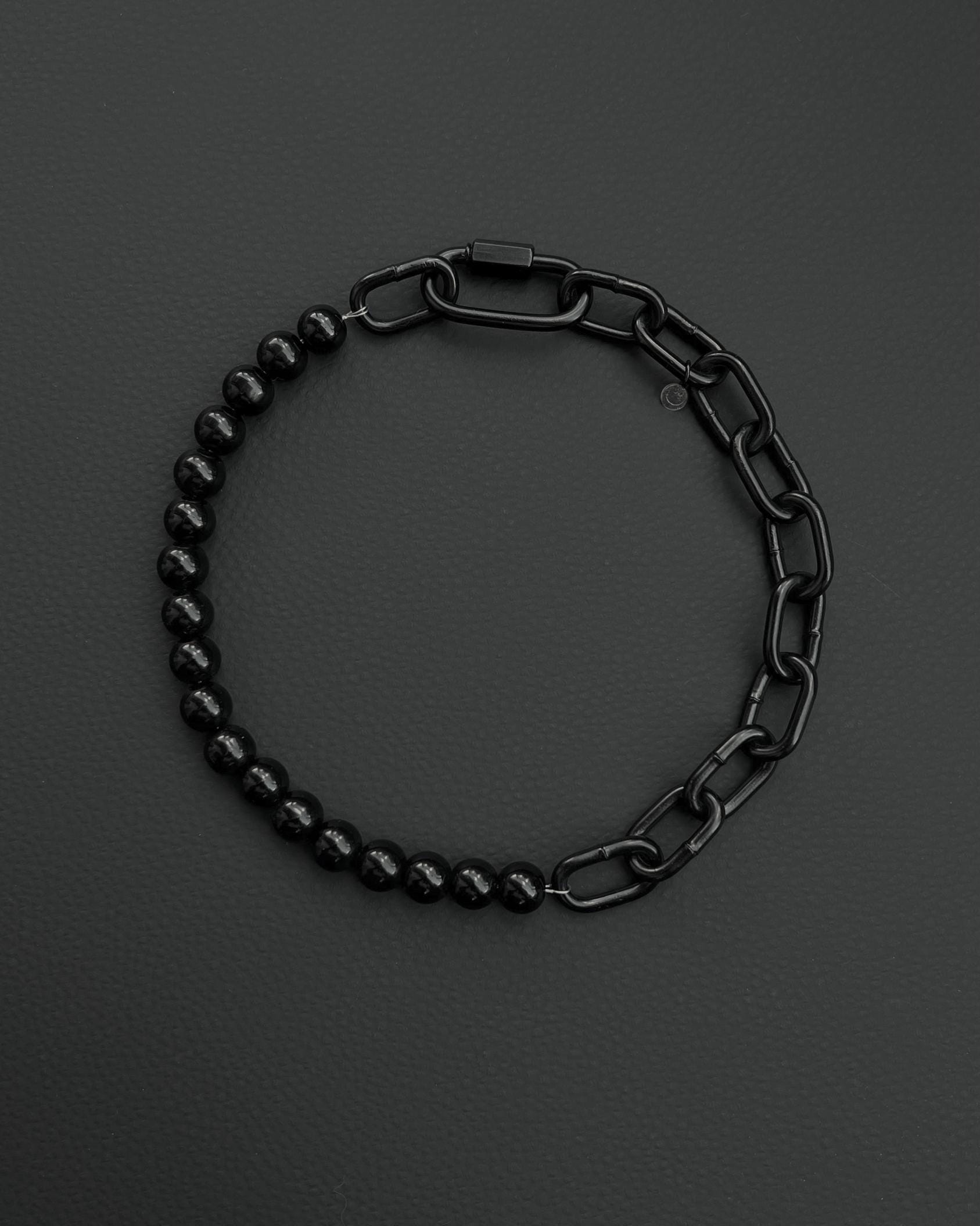 A handmade black industrial chain necklace with large, rectangular links.
The necklace is made of stainless steel. The necklace is made half-half from thick 4mm chain and 12mm glass black beads.The necklace includes a quick link carabiner and a smiley pendant.