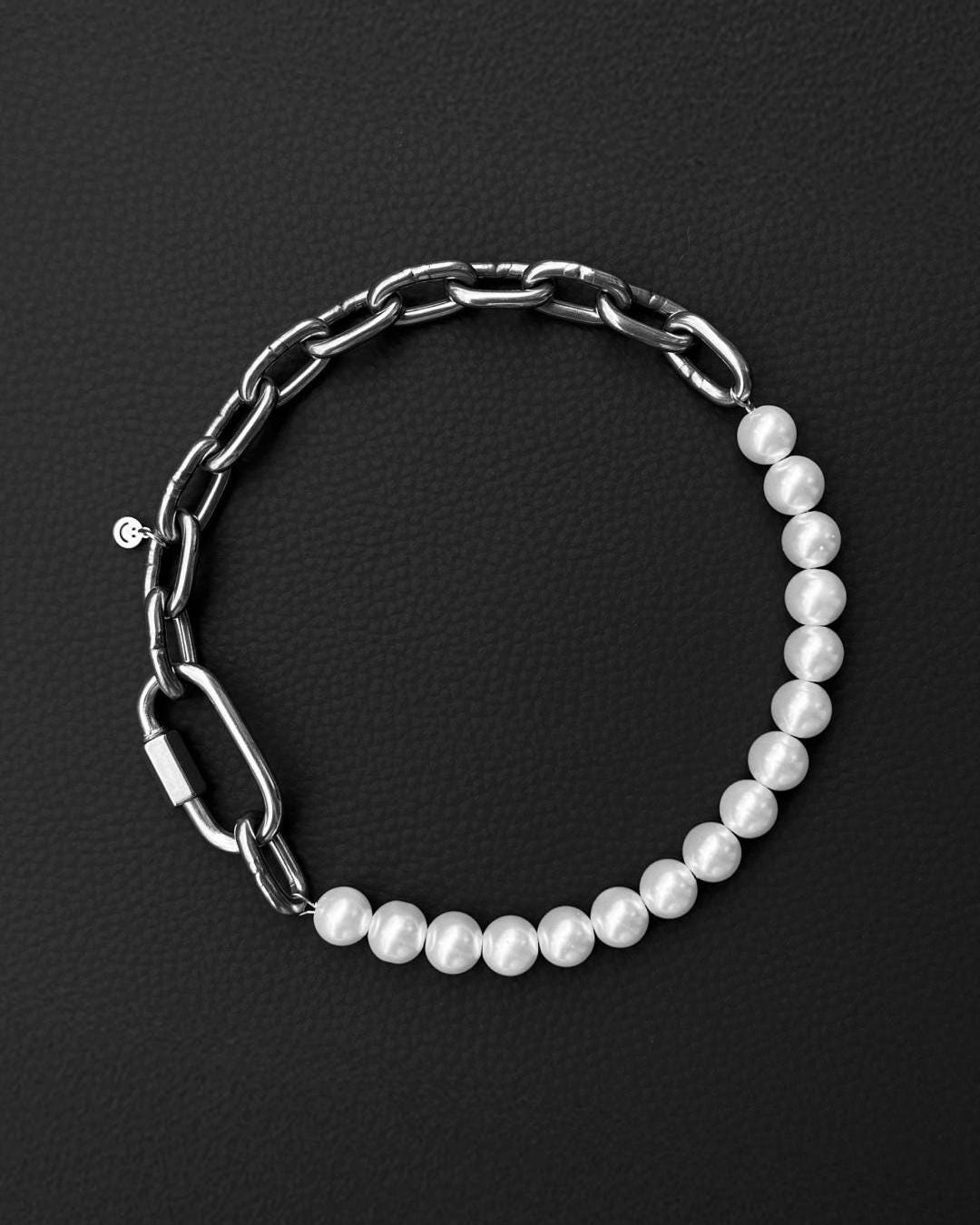 a stainless steel metal heavy industrial chunky chain necklace. half of the necklace is made out of chain and half of pearl glass beads, the necklace is closed with a rectangular clasp