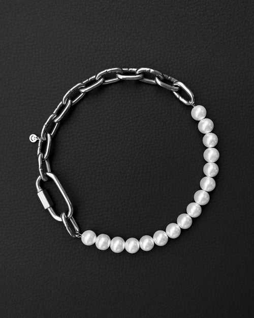 a stainless steel metal heavy industrial chunky chain necklace. half of the necklace is made out of chain and half of pearl glass beads, the necklace is closed with a rectangular clasp