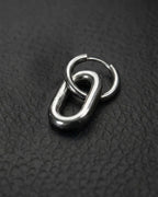 A single silver stainless steel metal earring with a distinctive design. It features a small hoop linked to a larger, elongated oval. The metal has a polished, reflective surface. The earring is set against a dark background.