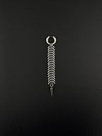 A silver-toned stainless steel hoop earring featuring a long, dangling chain composed of multiple curved, fishbone-like metal links. The chain terminates in a sharp, conical spike pendant, creating a vertical, articulated design with a polished metallic finish.