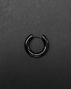 A single stainless steel circular thick big hoop earring with a polished black finish. The earring features a hinged closure mechanism with a thin post that secures into the main hoop body, creating a continuous, smooth, and rounded silhouette for the piece.