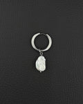 A silver-coloured stainless steel metal hoop earring featuring a single, irregular, white baroque pearl charm suspended from the bottom. The hoop has a smooth, polished finish and a hinged closure mechanism, while the pearl displays a textured surface.