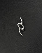 A single silver-toned stainless steel earring featuring an elongated, fluid, and abstract shape with smooth, polished surfaces in the cyber sigilism style. The design consists of two interconnected, curved segments that create an open, organic form with a post backing.