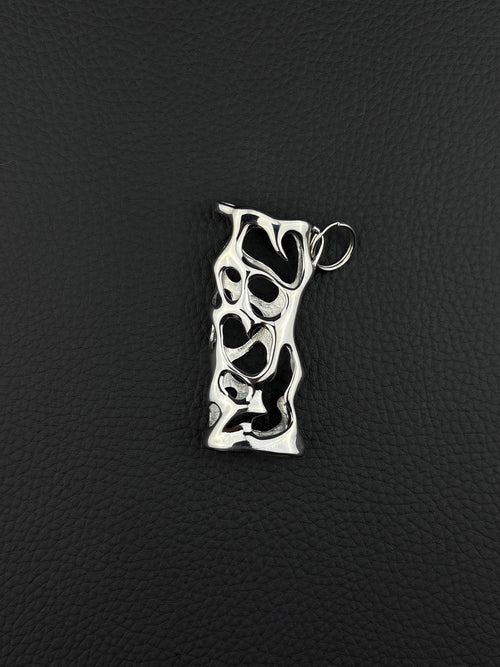 A silver-toned stainless steel pendant lighter sleeve featuring an elongated, irregular rectangular shape with a complex, organic cutout pattern throughout its surface. The metal has a polished, reflective finish and includes a small circular jump ring attached at the top. cyber sigilism style