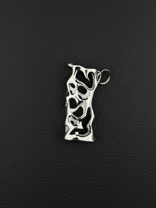 A silver-toned stainless steel pendant lighter sleeve featuring an elongated, irregular rectangular shape with a complex, organic cutout pattern throughout its surface. The metal has a polished, reflective finish and includes a small circular jump ring attached at the top. cyber sigilism style