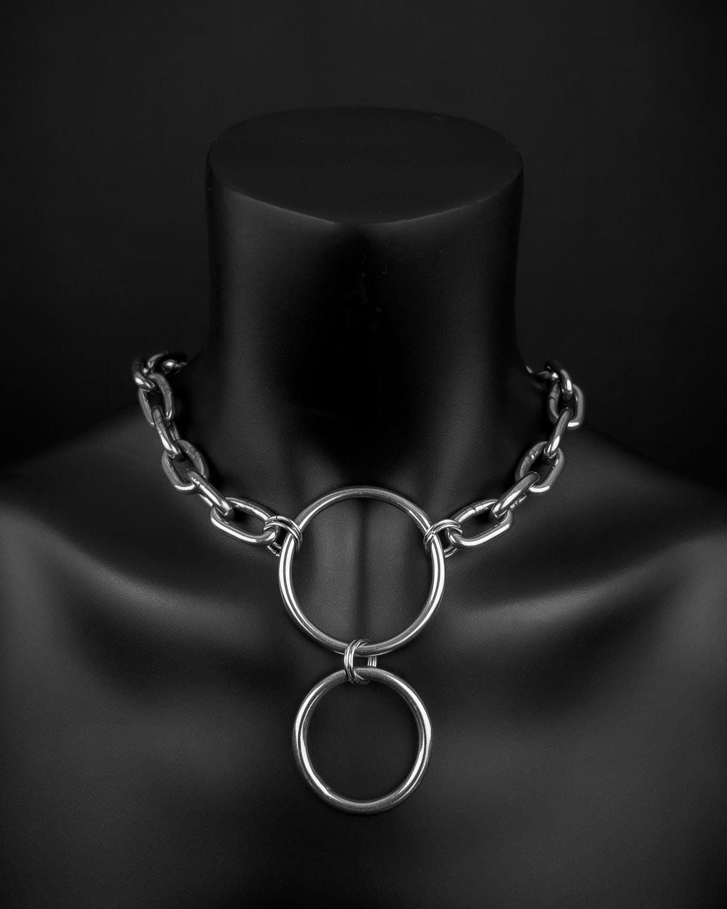 A handmade silver industrial chain ring necklace with large, rectangular links. The necklace is made of stainless steel. The necklace is made from thick 4mm chain and two rings. The necklace includes a quick link carabiner and a smiley pendant.