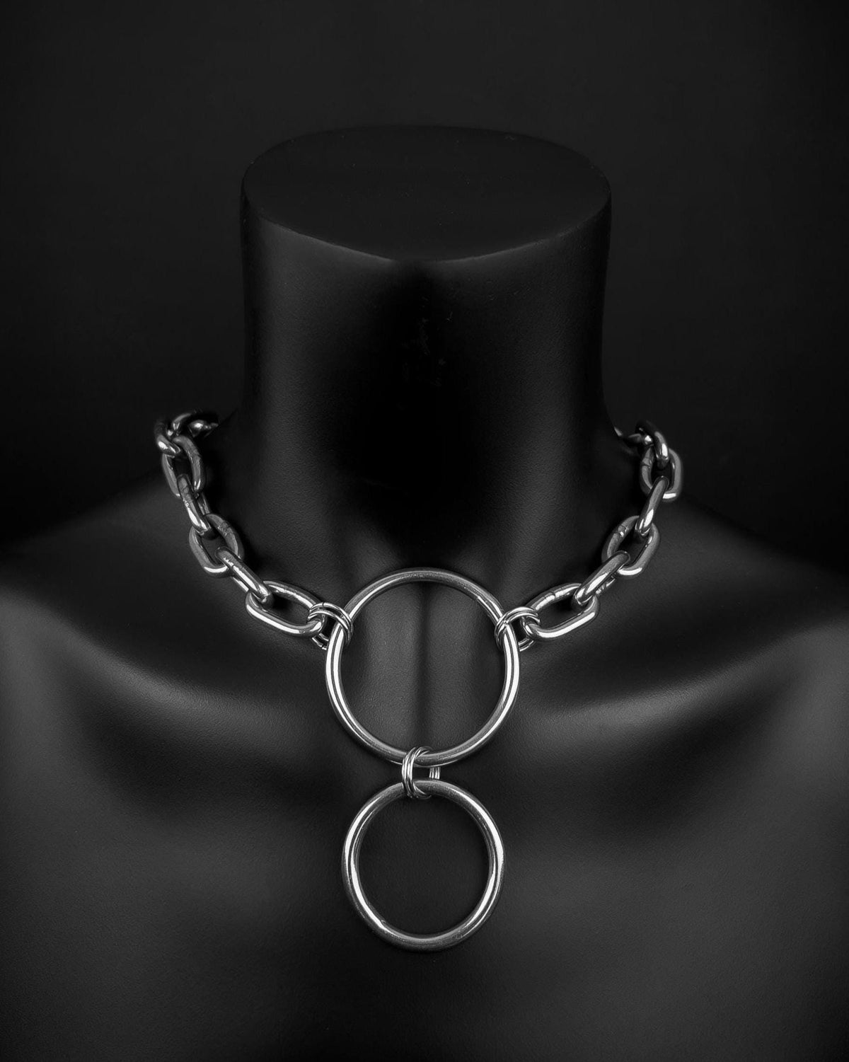A handmade silver industrial chain ring necklace with large, rectangular links. The necklace is made of stainless steel. The necklace is made from thick 4mm chain and two rings. The necklace includes a quick link carabiner and a smiley pendant.