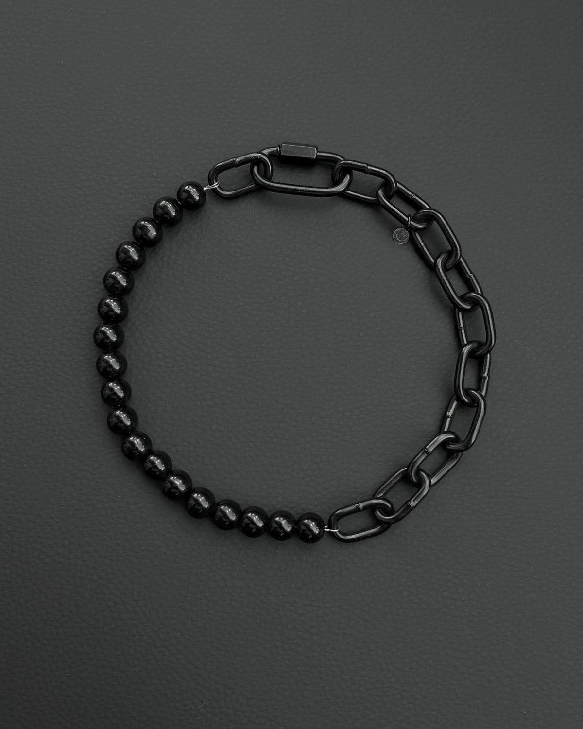 A handmade black industrial chain necklace with large, rectangular links.
The necklace is made of stainless steel. The necklace is made half-half from thick 4mm chain and 12mm glass black beads.The necklace includes a quick link carabiner and a smiley pendant.